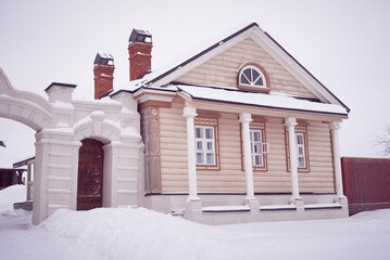 Vintage traditional wooden house with columns. Winter view.