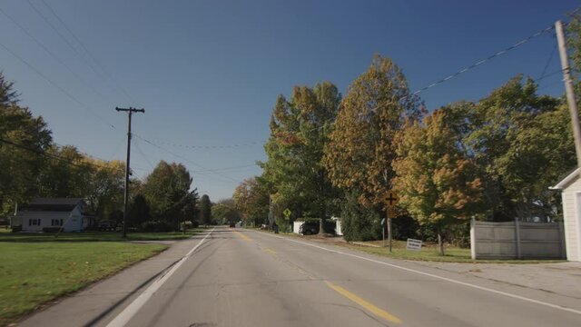 Drive through a small American town, view from the back window of the car to a typical street