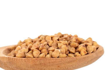 Uncooked organic buckwheat groats in a wooden spoon, close-up, isolated on white.