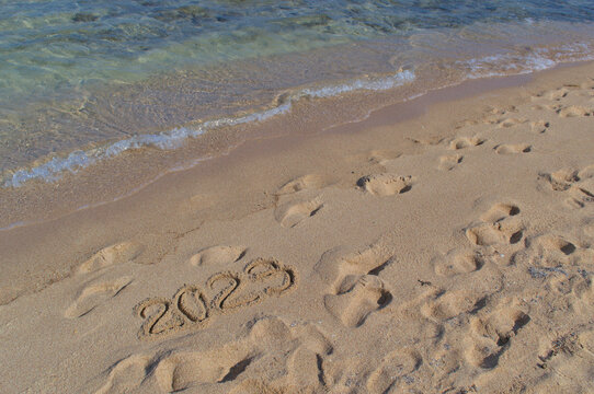 Inscription on the sand 2023 on the shores 
