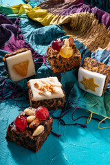 Rich sweet Christmas puddings loaded with dry fruits, nuts and spices on vibrant eastern background
