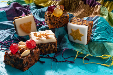 Rich sweet Christmas puddings loaded with dry fruits, nuts and spices on vibrant eastern background