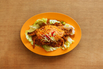 Singapore chili crab Served on orange Plate on wooden background top view