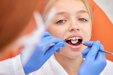 Close-up photo of child girl during dental tooth examination checkup. Attractive pretty caucasian...
