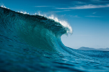 Ideal wave in Atlantic ocean. Blue glassy barrels and clear sky