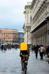 A bicycle courier at duomo square of milan.