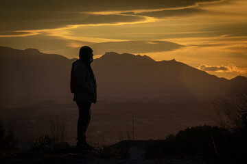 Silhouette of man on the mountain at sunset