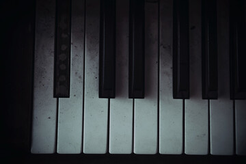 Black and white dirty keys of an abandoned piano. An old musical instrument. Play of light and...