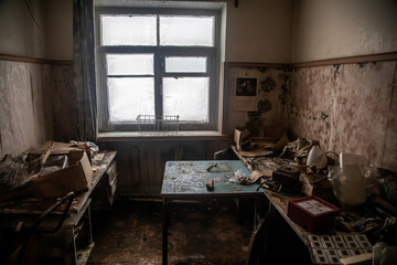 A dirty room with a window in an abandoned building. Ice on the window. The interior of an abandoned house. Shabby walls.