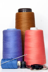 pink blue brown threads on a spool for sewing