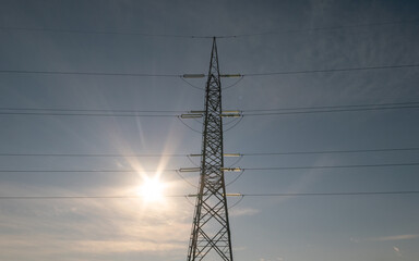 electricity: electricity conducting pylon which brings electricity to homes and cities for light and electrical installations. the sun as a reminder of the source of clean energy and light.