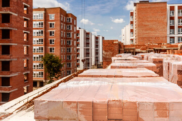 Fototapeta premium Construction Buildings. High-rise brick Houses under Construction. New Neighborhood of modern High-rise Buildings.