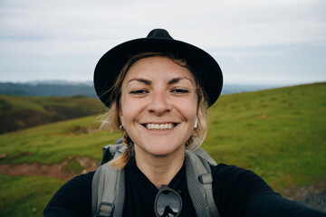 girl traveler pilgrim selfie on Camino de Santiago, to Compostela on the Pyrenees, Navarra, Spain
