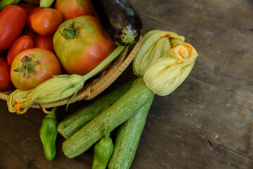Overhead shot of fresh vegetables arranged on an old wooden table.