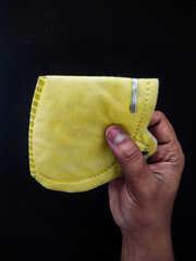 hand holding yellow N95 mask for covid19 omicron protection. photo taken in dark background .