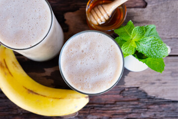 Banana fresh cocktail vanilla smoothies  fruit juice beverage healthy the taste yummy in glass drink episode good morning on wooden background from the top view.