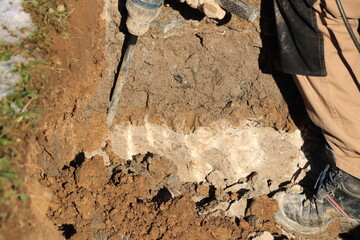 Arbeiter arbeitet mit einem Bohrhammer in einer Baugrube