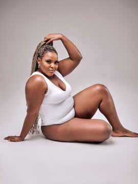 Self Acceptance, Love And Care. Portrait of smiling fat black woman with perfect skin and body isolated in studio background, free copy space. Gorgeous Lady with chubby body enjoy herself