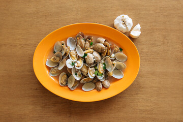 Chinese clams with black bean sauce and garlic on wooden table background