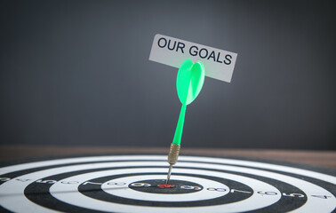 Paper with word Our Goals on dartboard.