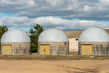 Obraz premium silver silos on agro manufacturing plant for processing drying cleaning and storage of agricultural products, flour, cereals and grain. an old warehouse on a farm with a round roof