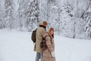 Fototapeta na wymiar Couple in love walks through the winter forest