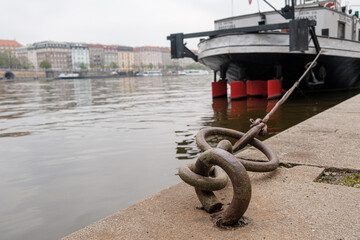 Obraz premium Ship or vessel moored on the embankment of the Vlatva river in Prague in cloudy and grey autumn day. 