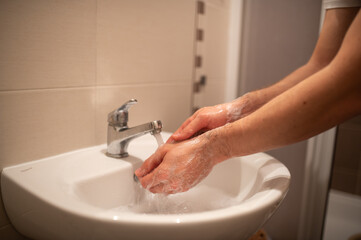 a man is washing his hands in a home bathroom