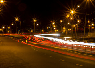 Moving car with blur light through roads and highways in twilight city. Night cityscape.