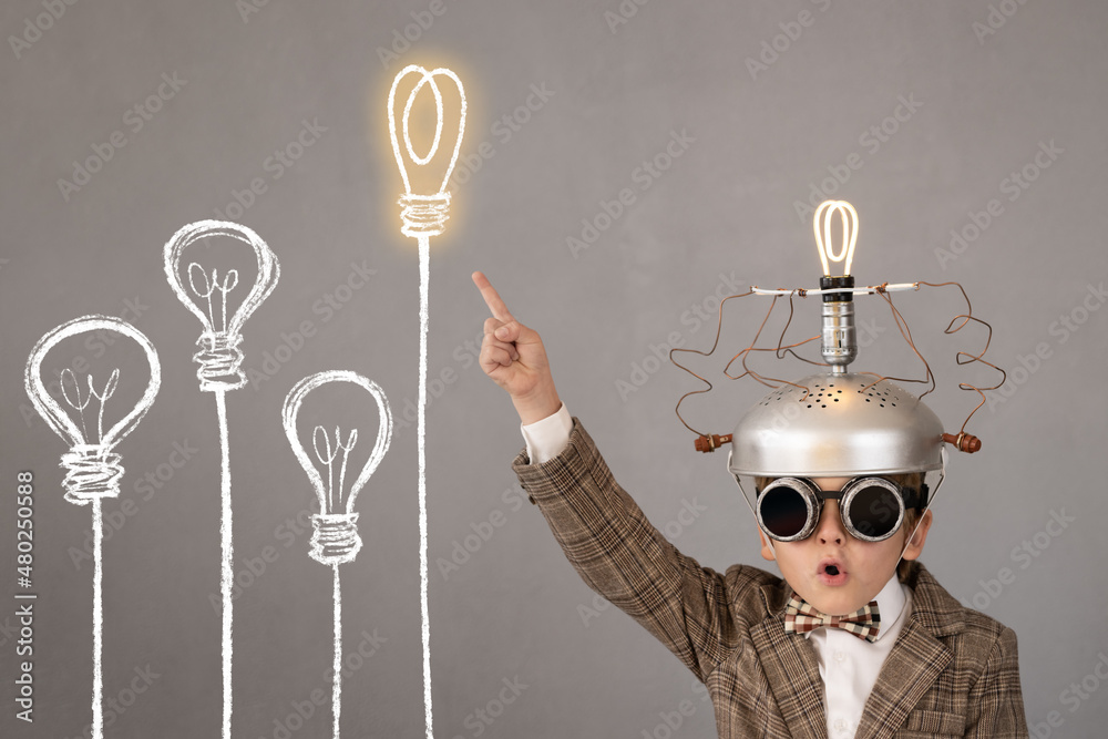 Poster Smart child wearing funny helmet with illuminated lightbulb