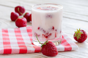 strawberry yogurt with strawberry pieces on a wooden table