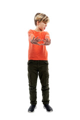 The boy stands with his arms outstretched, palms forward. A guy in dark jeans and an orange sweater. Sign no, disgust and rejection. Isolated on white background. Vertical.