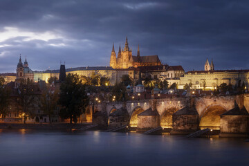 Prague Castle and Charles bridge with dramatic clouds at night, Czech Republic