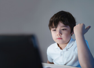 Happy school kid having fun watching cartoon on tablet, Child using digital pad searching the ideas on internet for his homework, Home schooling, Home learning or E-learning online education