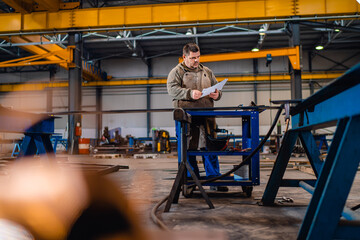 Industrial worker looking at blueprint