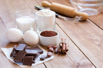 Ingredients for making chocolate chip cookies on a wooden background