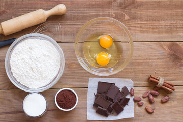 Ingredients for making chocolate chip cookies on a wooden background