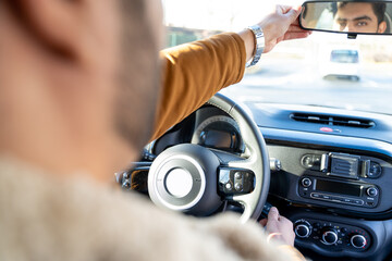 Caucasian or eastern ethnicity man in jacket starting engine with ignition key, align rearview...