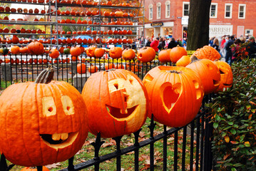 Pumpkins are placed to an iron fence, like heads on a stake, at a pumpkin festival in New England - Powered by Adobe