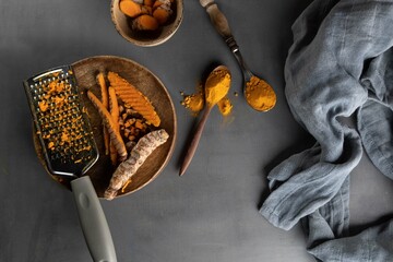 Healthy spices curcuma poweder and roots on grey background .Copy space