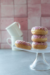 Donuts with pink and icing on a pink background. Sweet pastries.