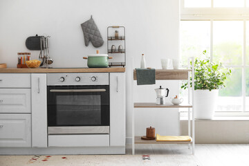 Interior of light kitchen with shelving unit