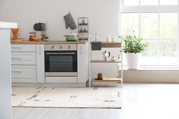 Interior of light kitchen with shelving unit