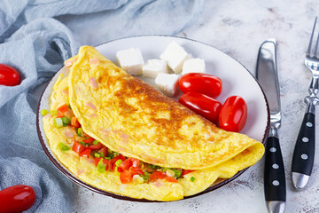 Fried omelette with beef, tomato, onion and herbs. Delicious breakfast with scrambled eggs