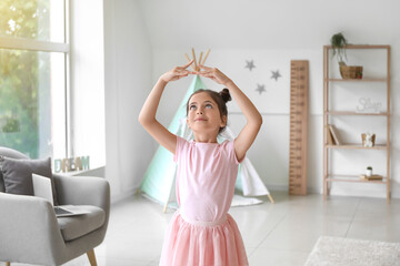 Adorable little ballerina dancing at home