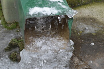 an icy gutter with a large amount of ice on it that interferes with the normal flow of water from...