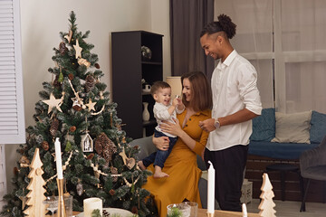 Happy young family with little son nerby Christmas tree