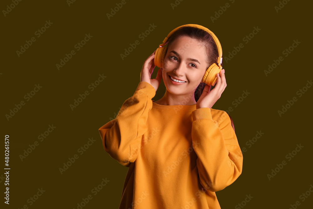 Canvas Prints Cool young woman listening to music on dark background