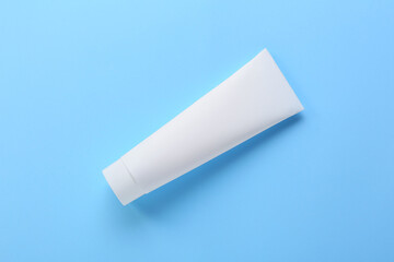 Tube with tooth paste on blue background