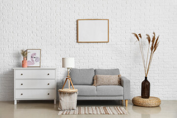 Interior of light living room with sofa, commode and coffee table
